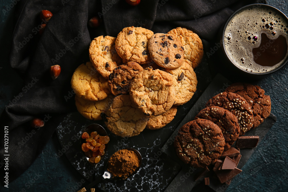 Boards with tasty homemade cookies and cup of coffee on black background