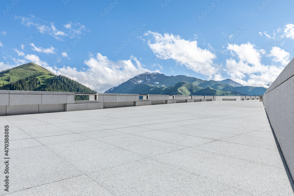 Empty square floor and mountains under blue sky