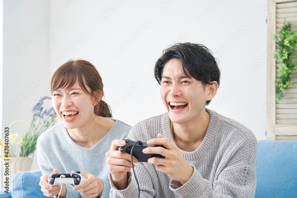 テレビゲームで遊ぶ男女