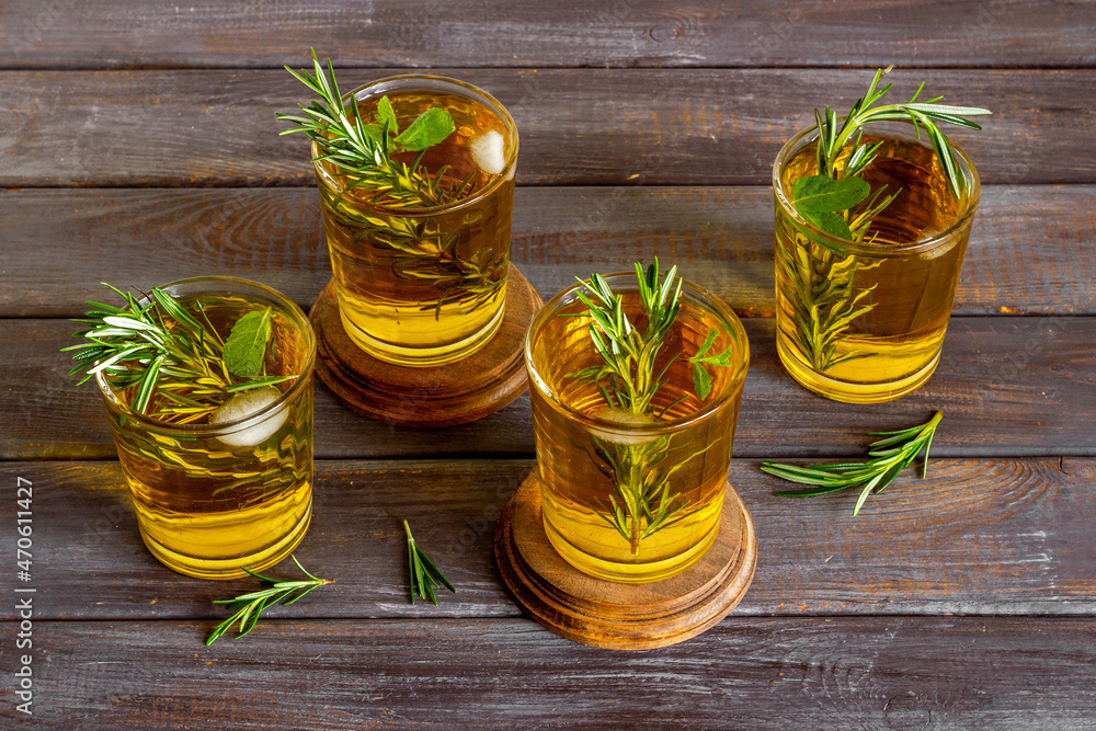 Fefreshing drink of cold tea and rosemary herbs in glasses