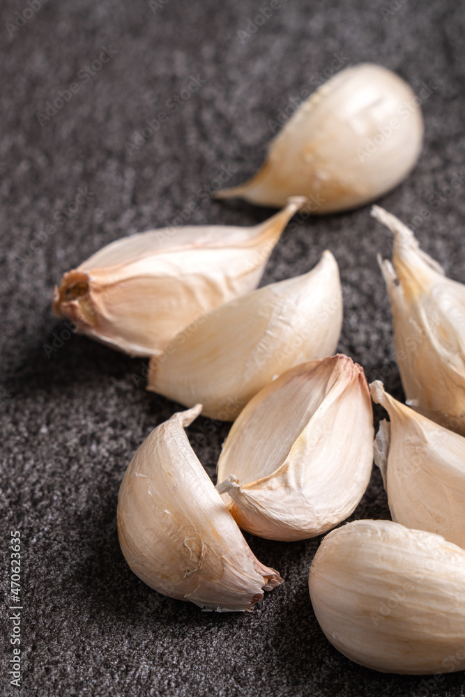 Fresh garlic cloves on black table background.