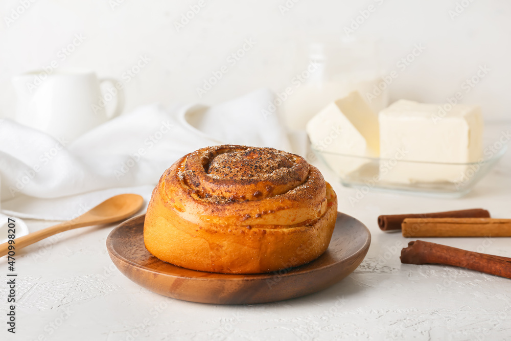 Plate of tasty cinnamon roll on white background