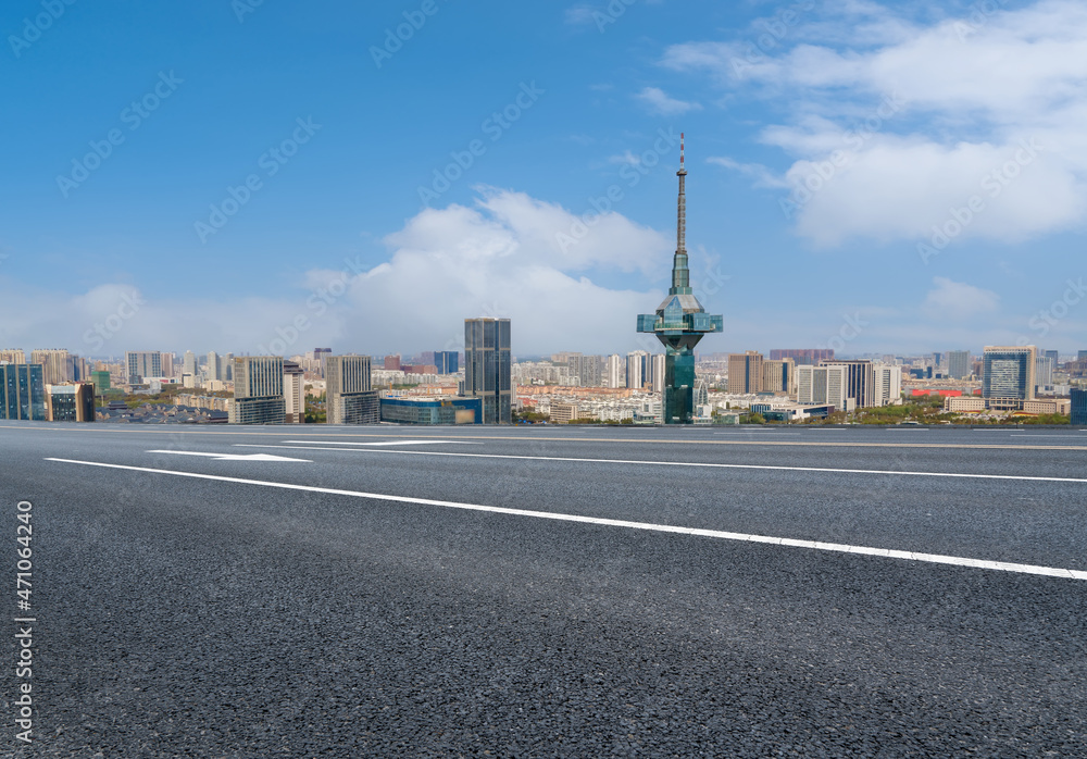 空旷的柏油路、城市天际线和建筑景观，中国。