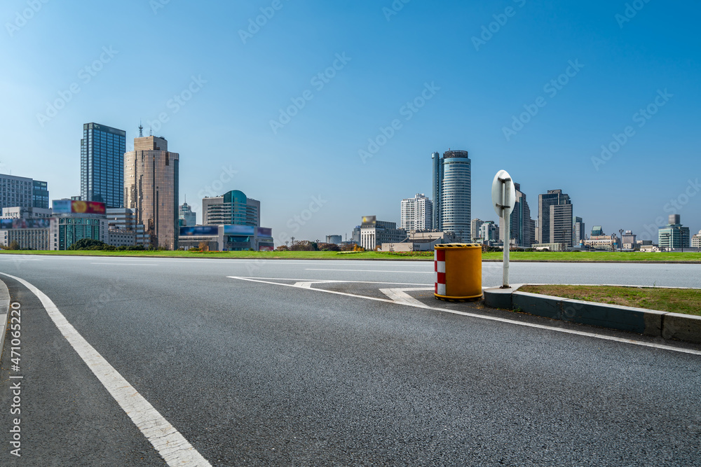 空旷的柏油路、城市天际线和建筑景观，中国。