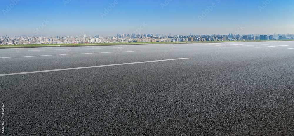 空旷的柏油路、城市天际线和建筑景观，中国。