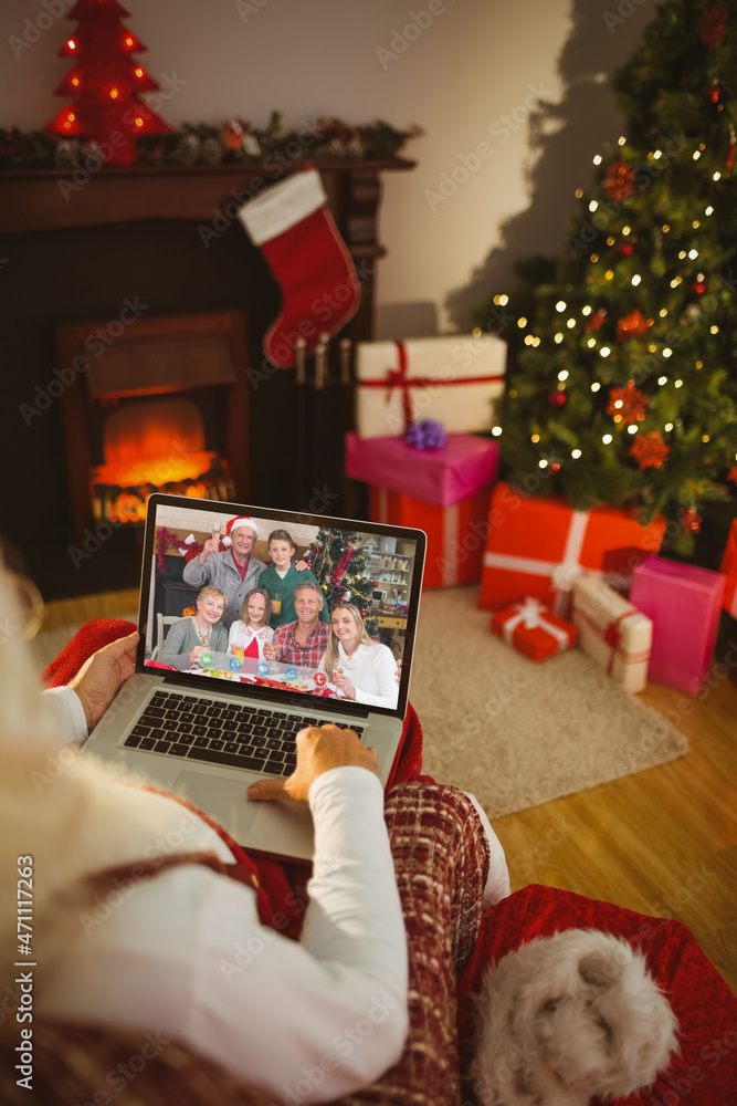 Santa claus making laptop christmas video call with smiling caucasian multi generation family