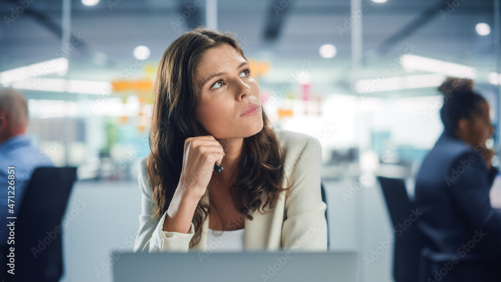 Young Serious Female Manager Using Computer in Modern Office. Overworked Tired Employee Dealing with