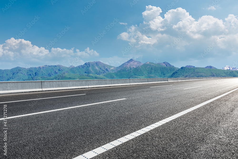 蓝天下的柏油路和山。公路和山的背景。