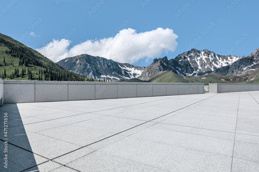 Empty square floor and mountains under blue sky. Road and mountain background.