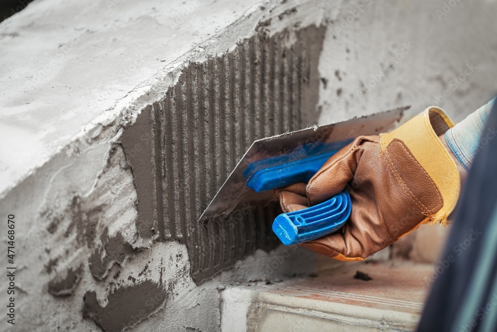 A worker with gloves lays down and dismantles the ceramic tiles of the stairs