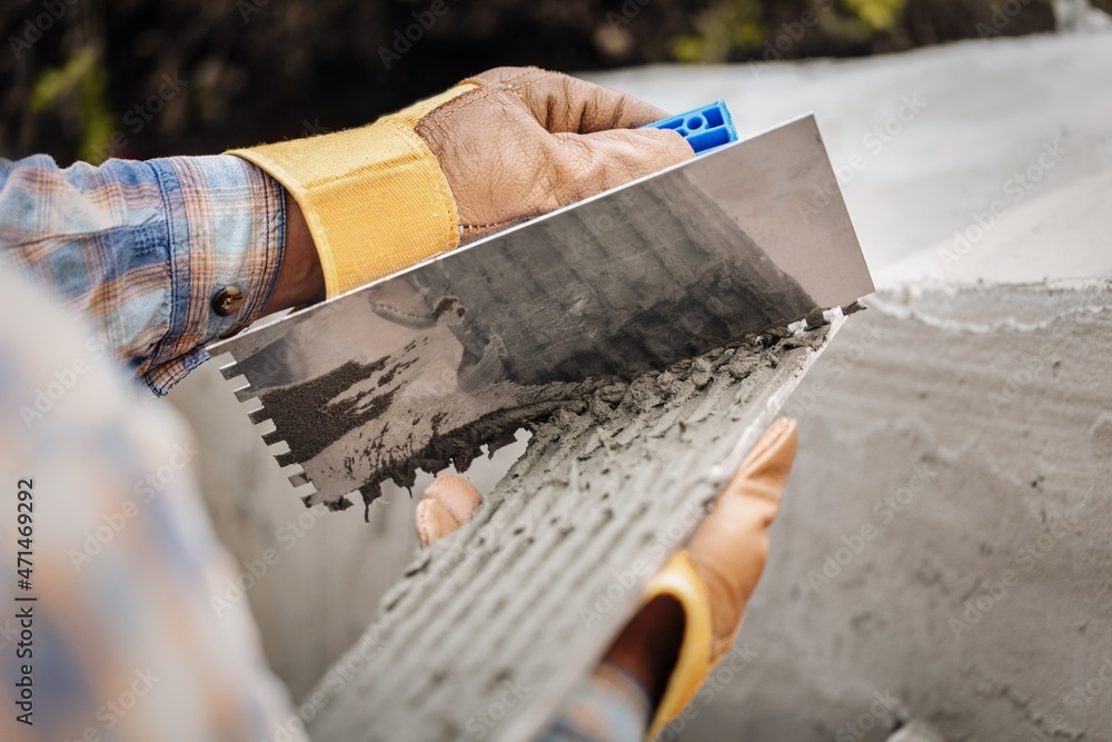 A worker with gloves lays down and dismantles the ceramic tiles of the stairs