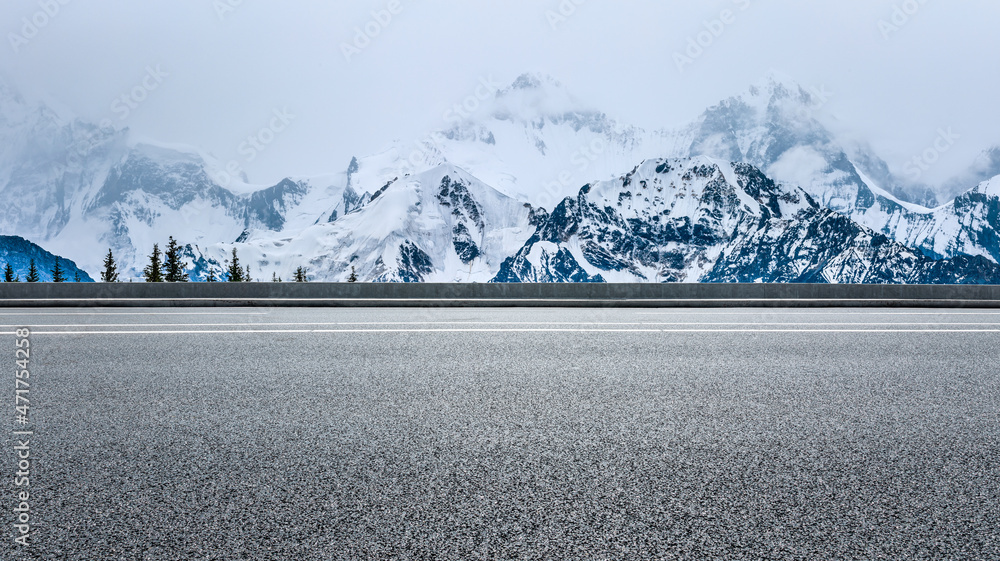 蓝天下的沥青路和雪山。公路和山脉背景。