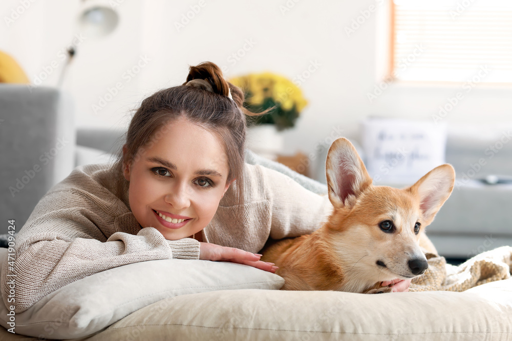 家里有一只可爱的柯基犬躺在床上的年轻女子