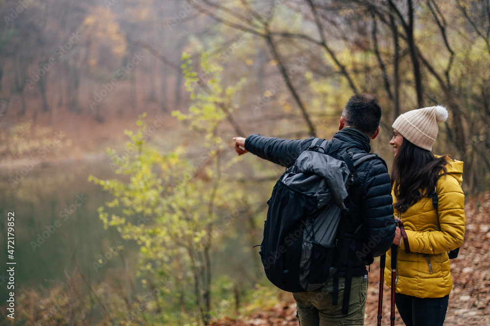 Excited caucasian man, showing his wife where they might hike ne