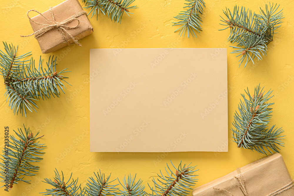 Composition with blank card, fir branches and Christmas gifts on color background