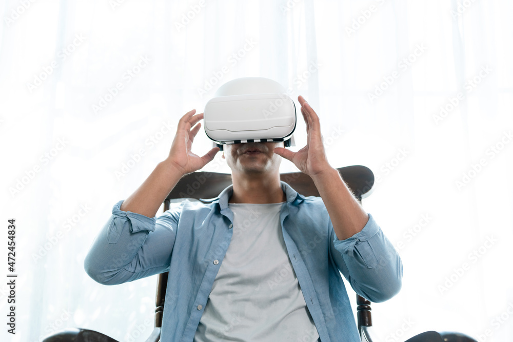 Hispanic man wearing virtual reality headset watching inside cyberspace. he is operating the simulat