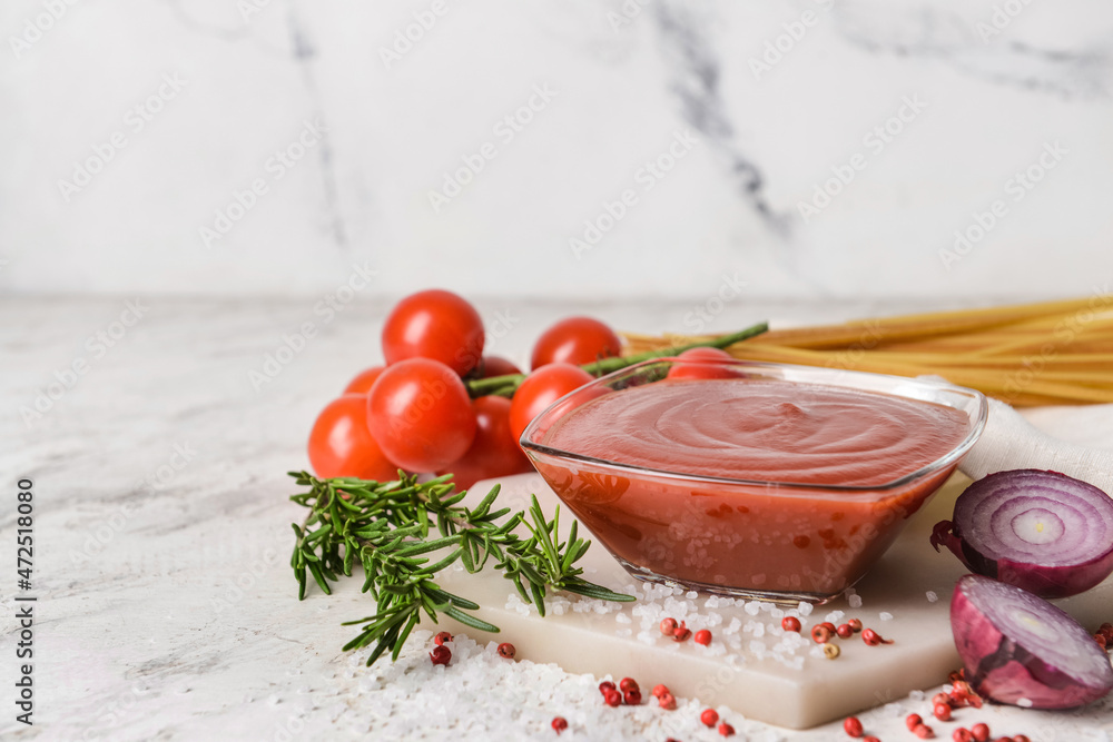 Bowl with organic tomato sauce on white background