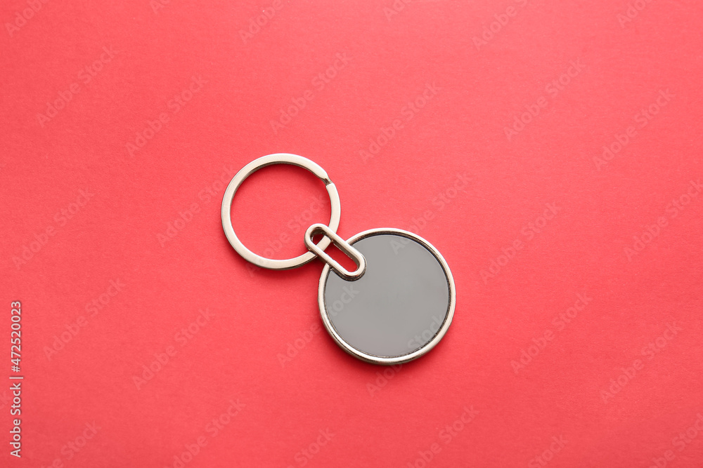 Stylish round keychain on red background