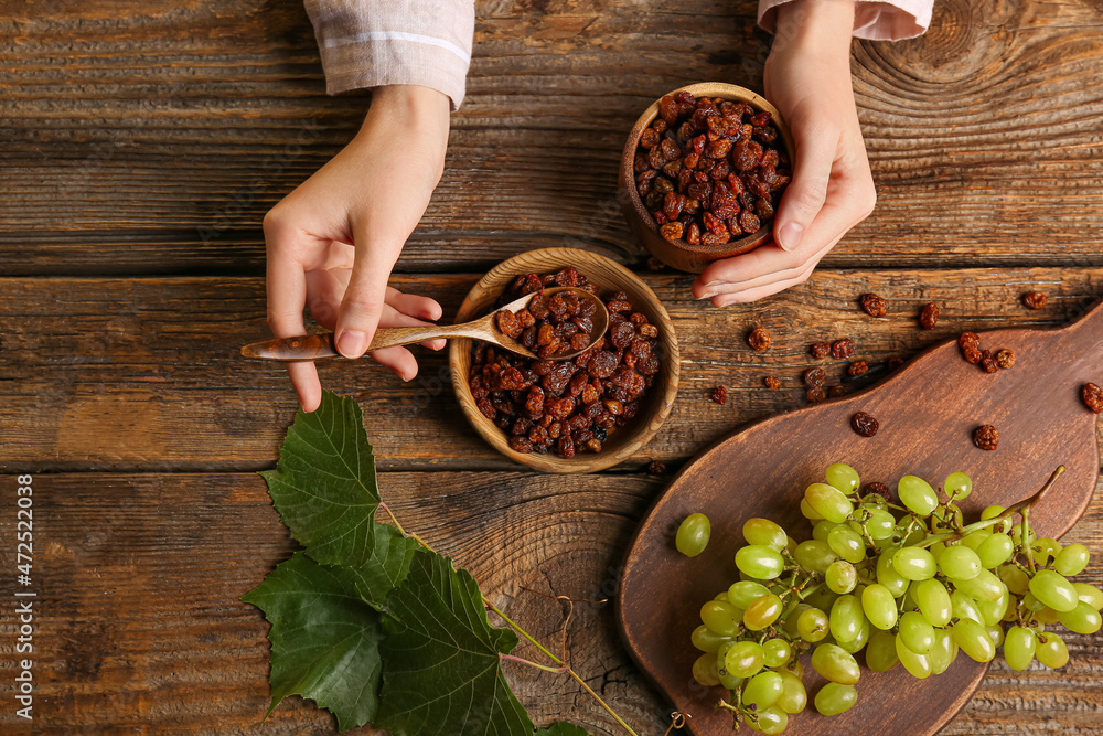 Woman with sweet raisins in bowls at table