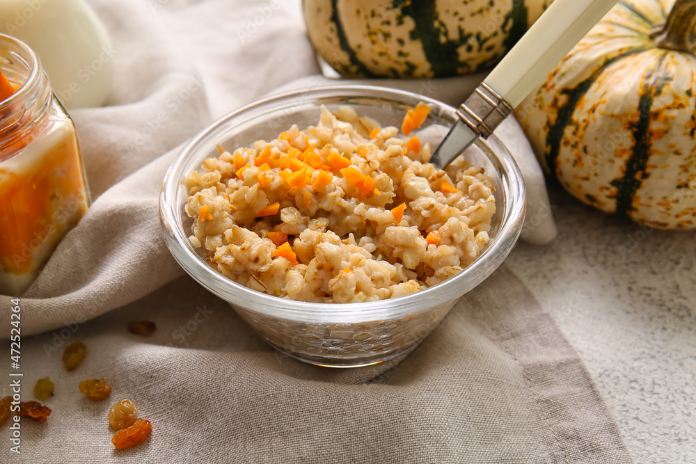 Bowl of tasty oatmeal with pumpkin on white background