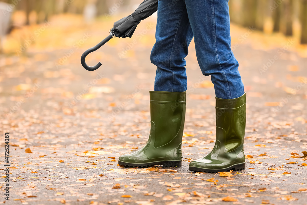 Man wearing gumboots in park on autumn day