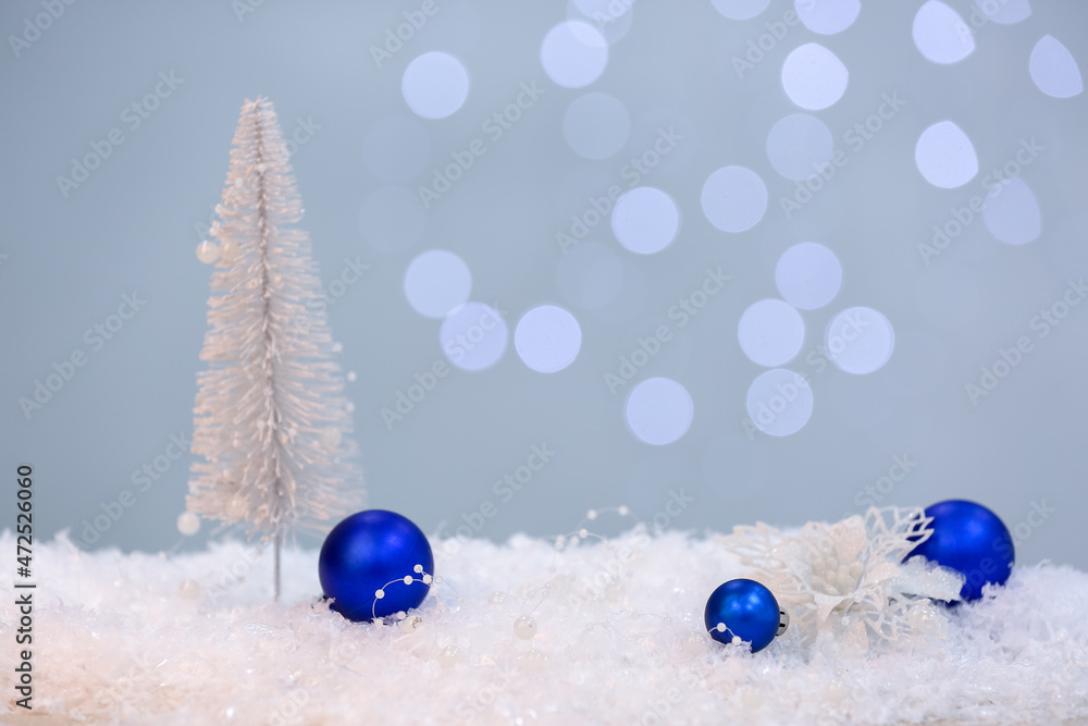 Christmas balls on snow against blurred lights