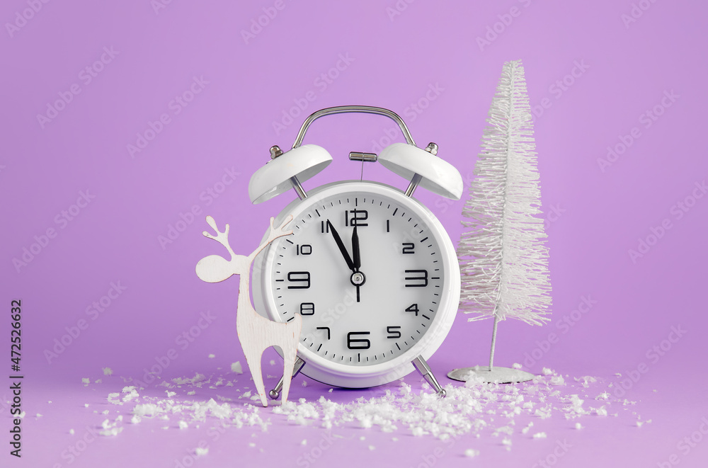 Alarm clock, Christmas decorations and snow on color background