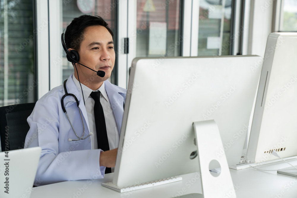 Doctor wearing headset talking actively on video call in a clinic or hospital . Concept of telehealt