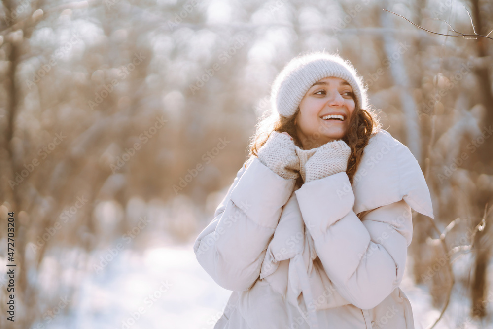 穿着冬装的快乐女人在雪地公园里散步。自然、假日、休息、旅行理念