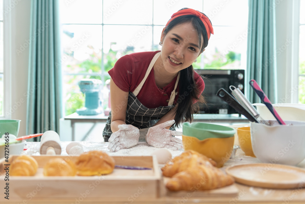 Happy asian woman is cooking cookies and having fun in the kitchen. She making video for her culinar