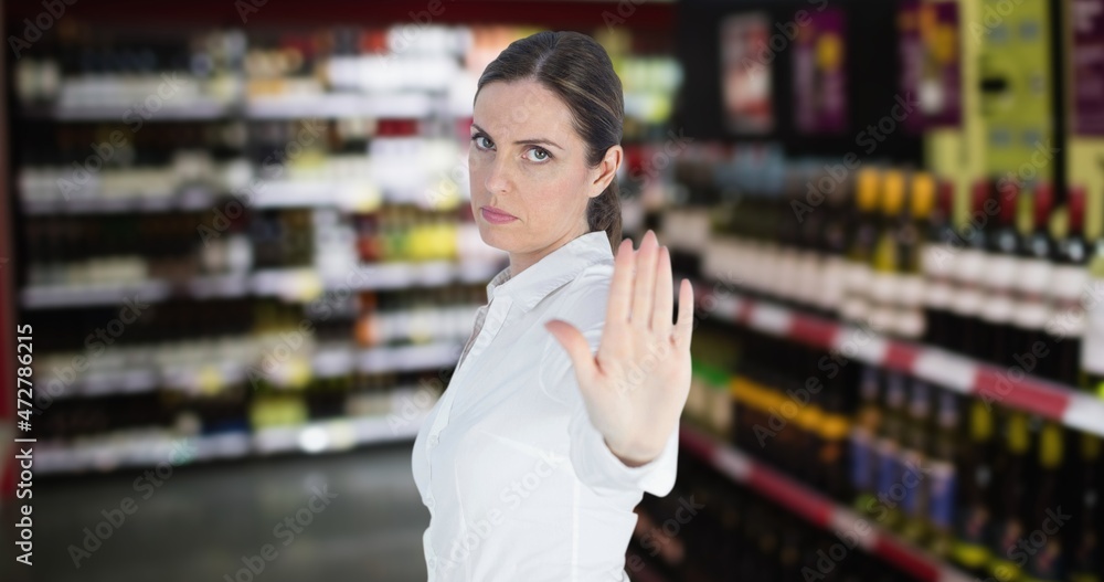 Portrait of angry young woman showing stop gesture with hand at wine shop