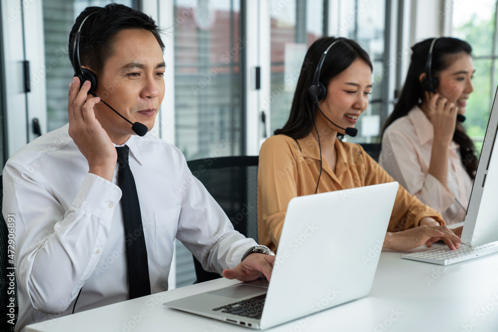 Business people wearing headset working actively in office . Call center, telemarketing, customer su