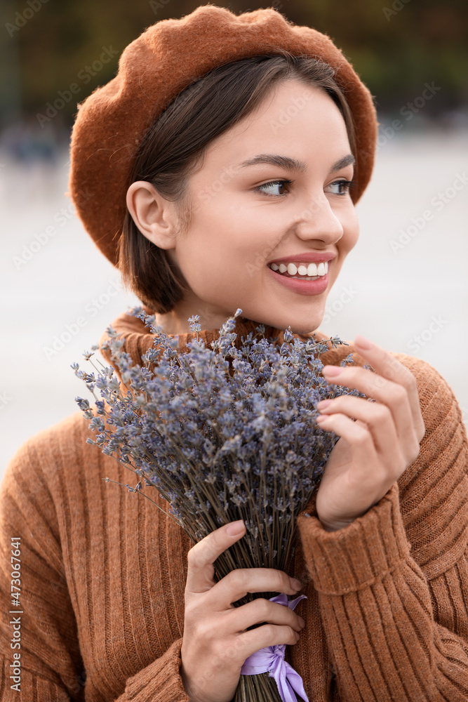 户外带着薰衣草花的年轻微笑女人