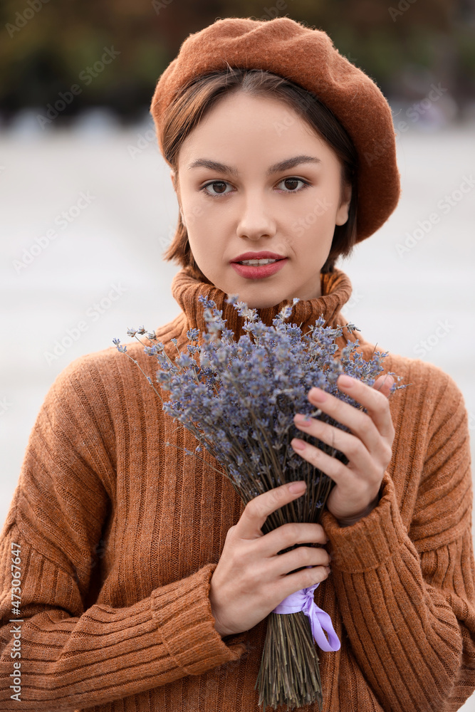 户外手持一束薰衣草花的年轻女子肖像