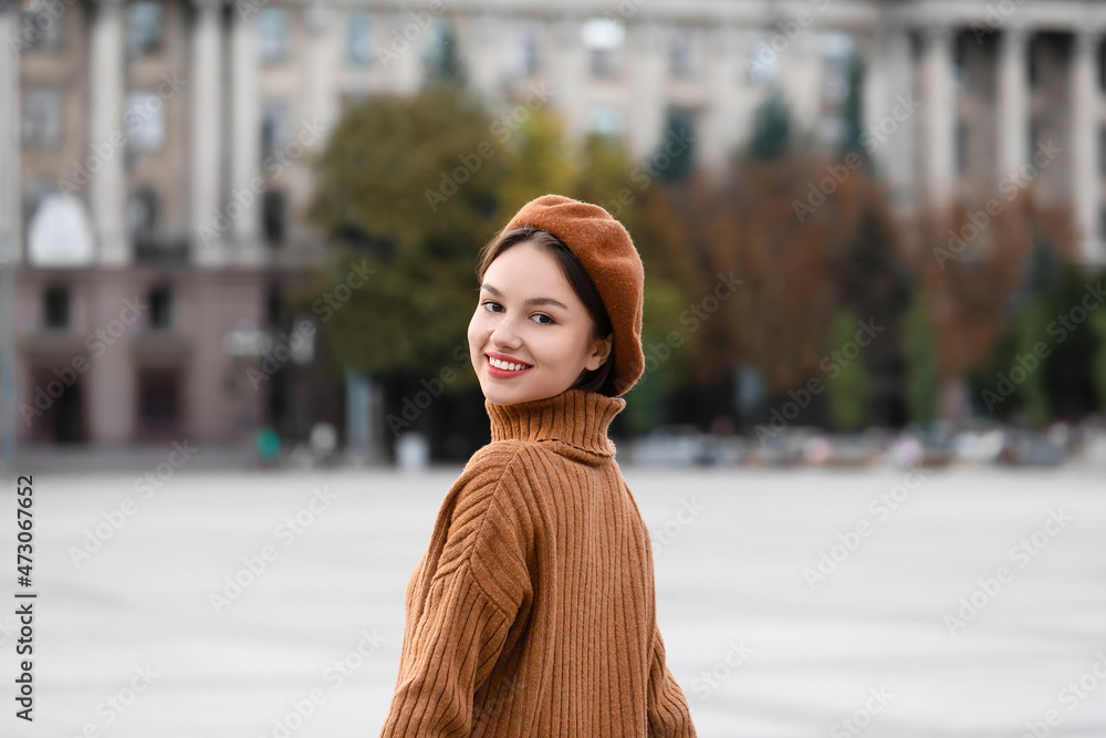 城市街道上戴贝雷帽微笑的美丽女人