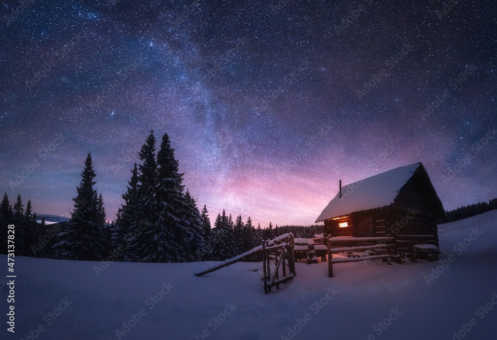 雪山木屋的奇妙冬季景观。银河和雪的星空