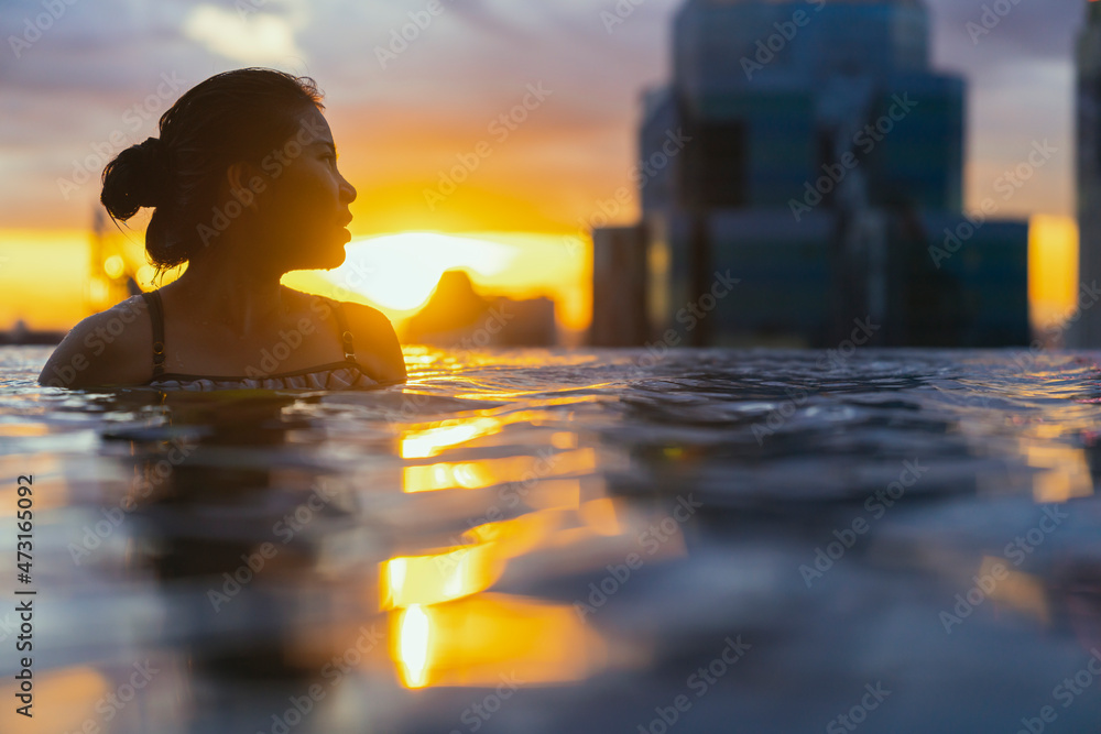 亚洲女性的黑色轮廓在暑假假期泼水，穿着无边泳衣放松