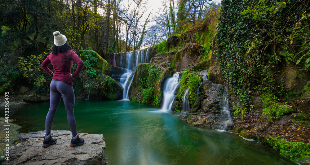 Hiker girl observing a waterfall