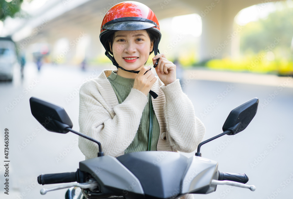 亚洲女子在上班路上开摩托车