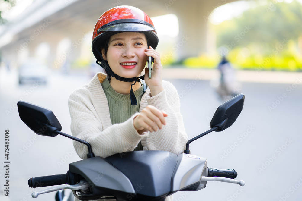 一名亚洲女子在上班途中驾驶摩托车