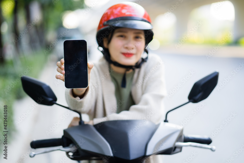 Asian woman driving a motorbike on her way to work