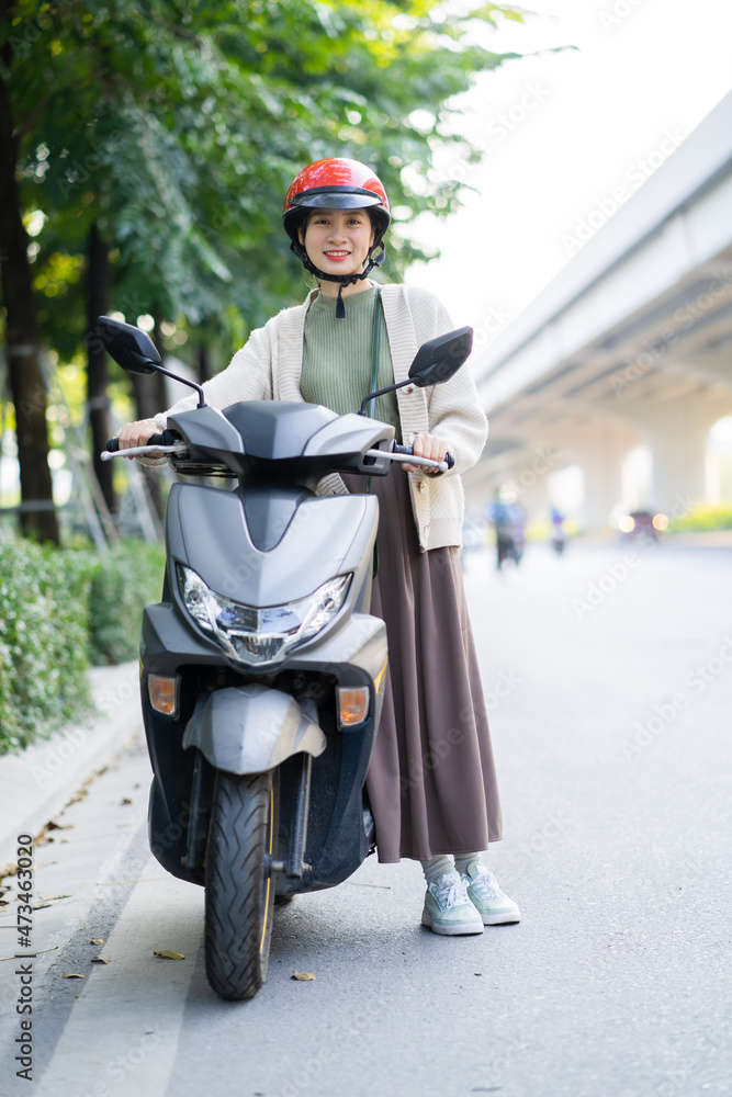 一名亚洲女子在上班途中驾驶摩托车