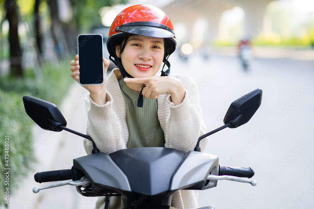 一名亚洲女性在上班途中驾驶摩托车