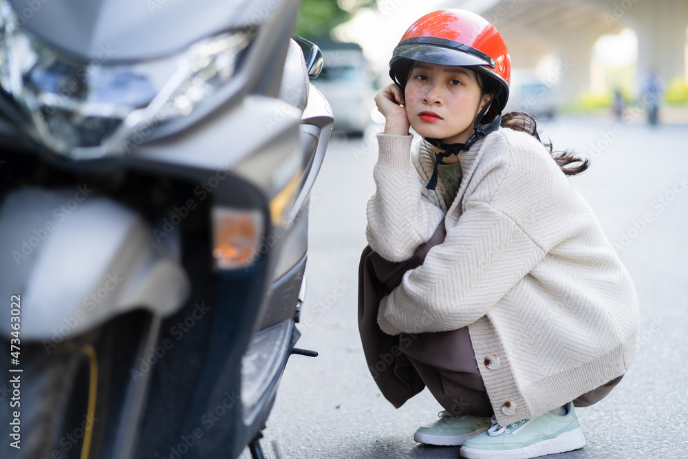 亚洲女孩在上班的路上摔坏了摩托车