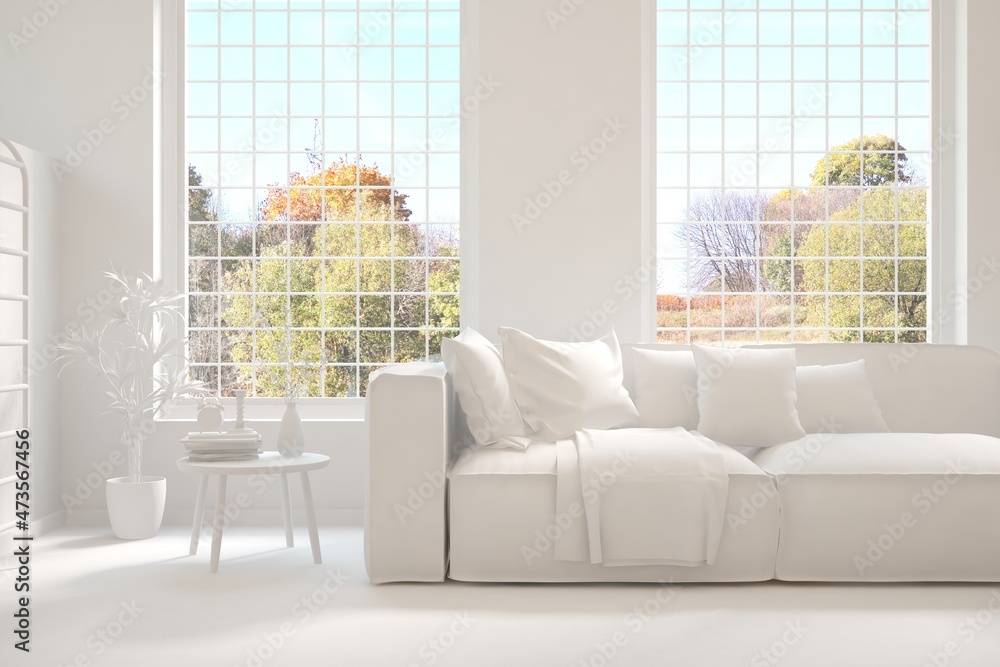 Stylish room in white color with sofa and autumn landscape in window. Scandinavian interior design. 