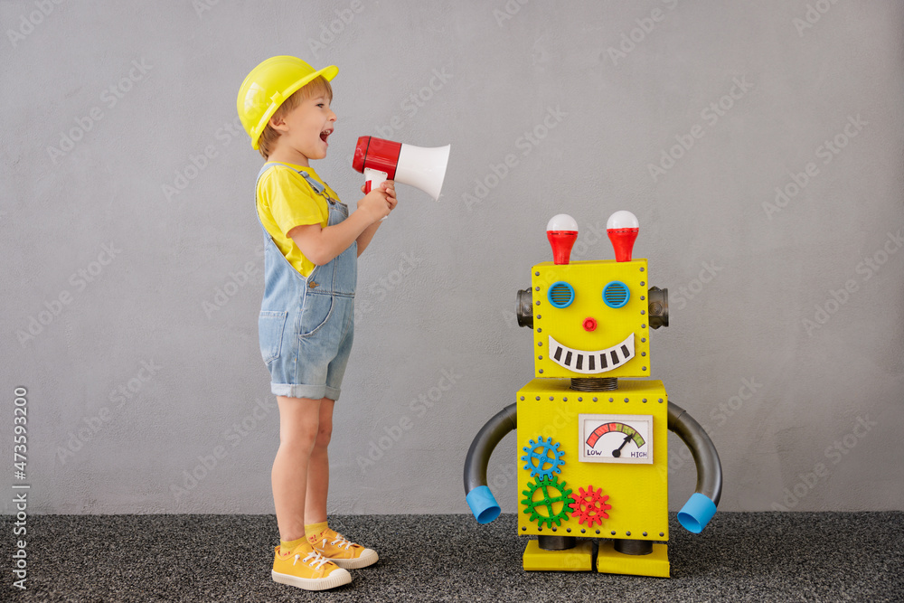 Happy child playing with robot