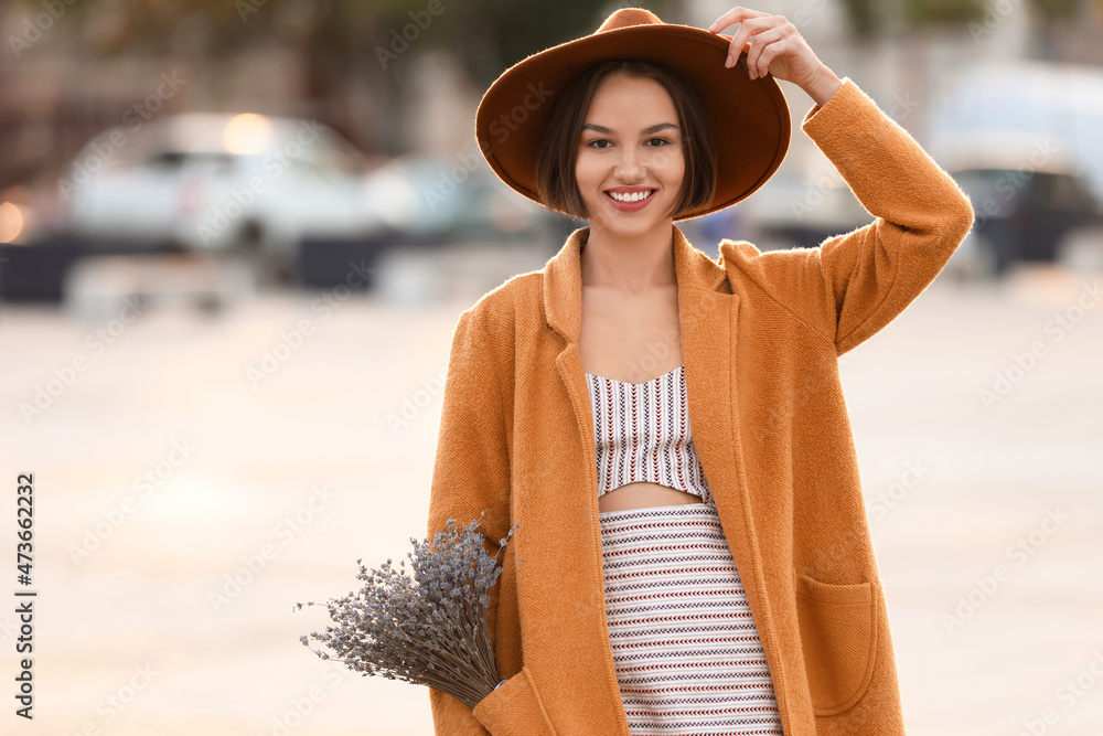 美丽的微笑女人，在城市街道上口袋里放着一束薰衣草花