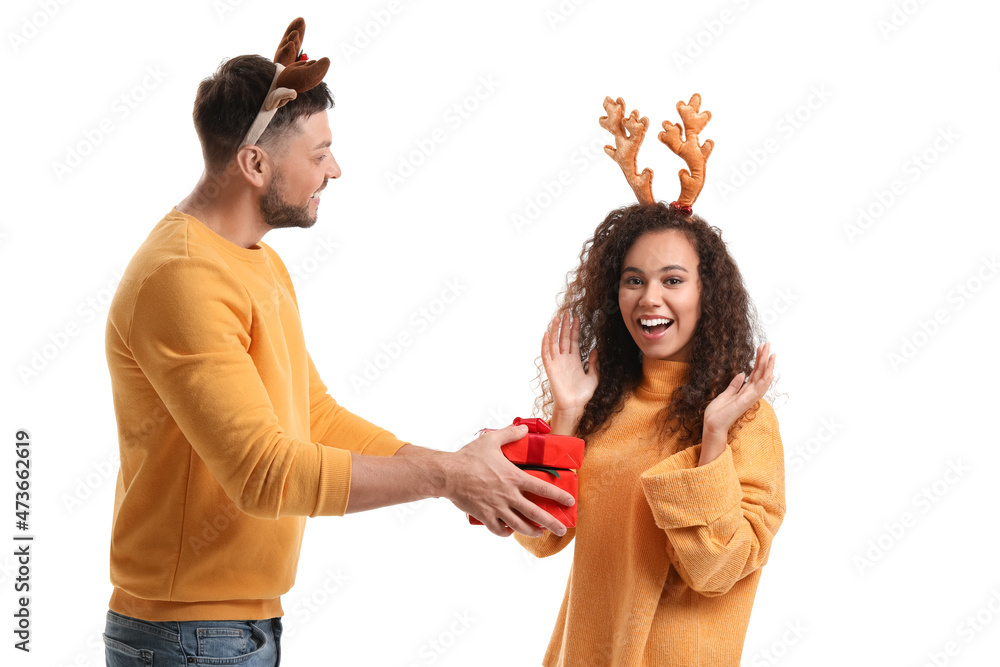 Happy couple with Christmas gift on white background