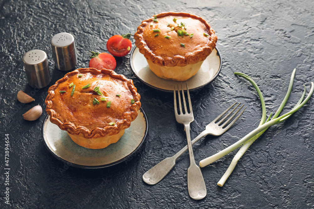 Tasty beef pot pies on dark background