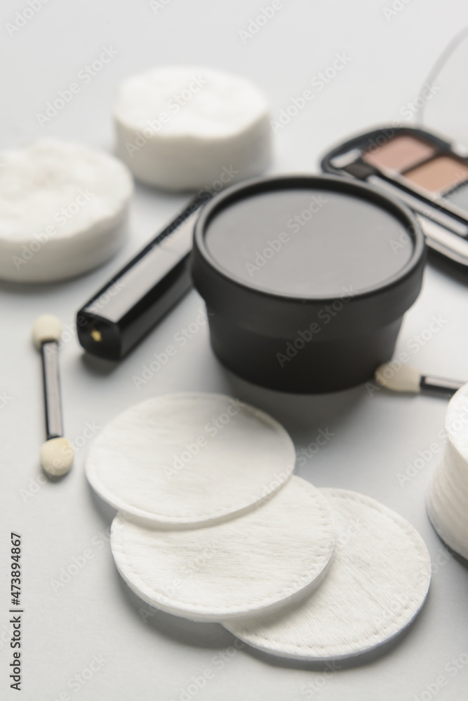 Soft cotton pads and cosmetics on light table, closeup